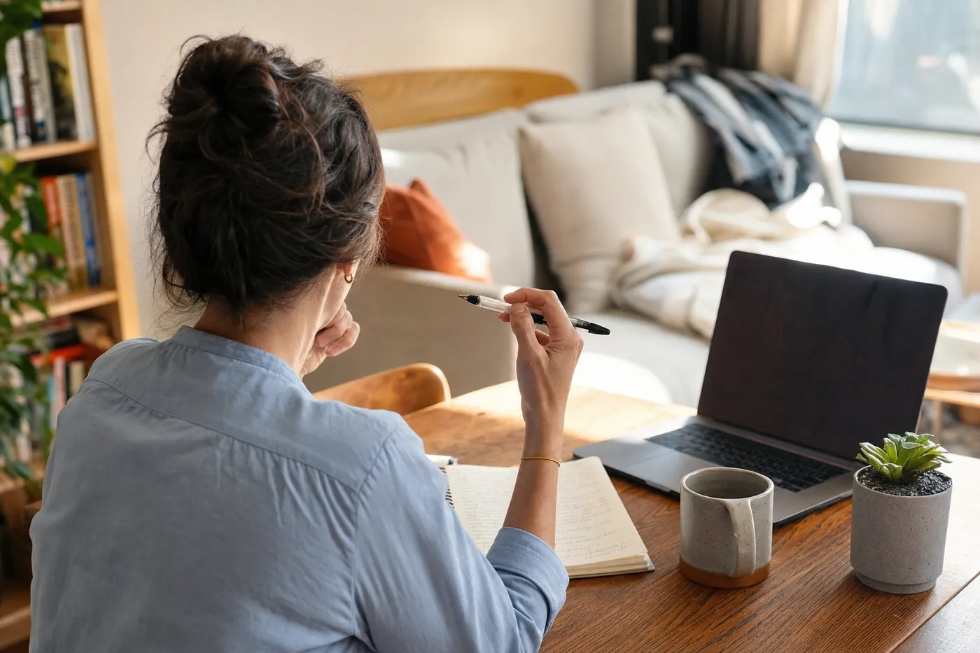 A job seeker looking puzzled at a sunlit home desk, trying to track down a missing job description.