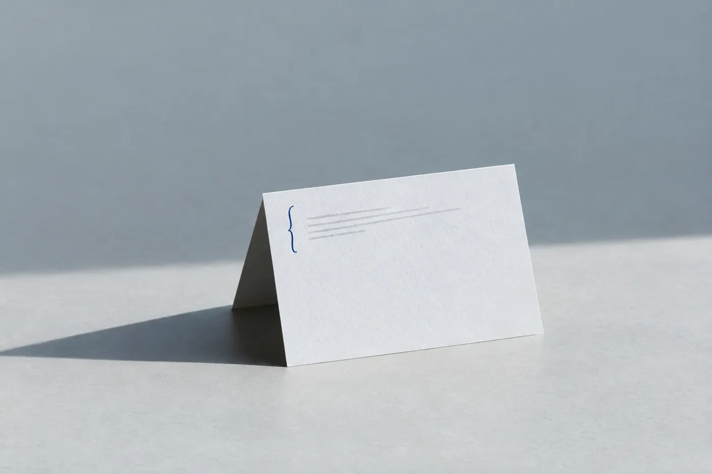 A folded resume page showing only the top education section, marked with a blue ink bracket, on a grey surface.