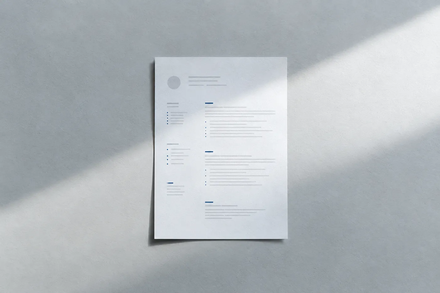 A single sheet of neatly structured resume paper with wide margins resting alone in a sharp beam of light.