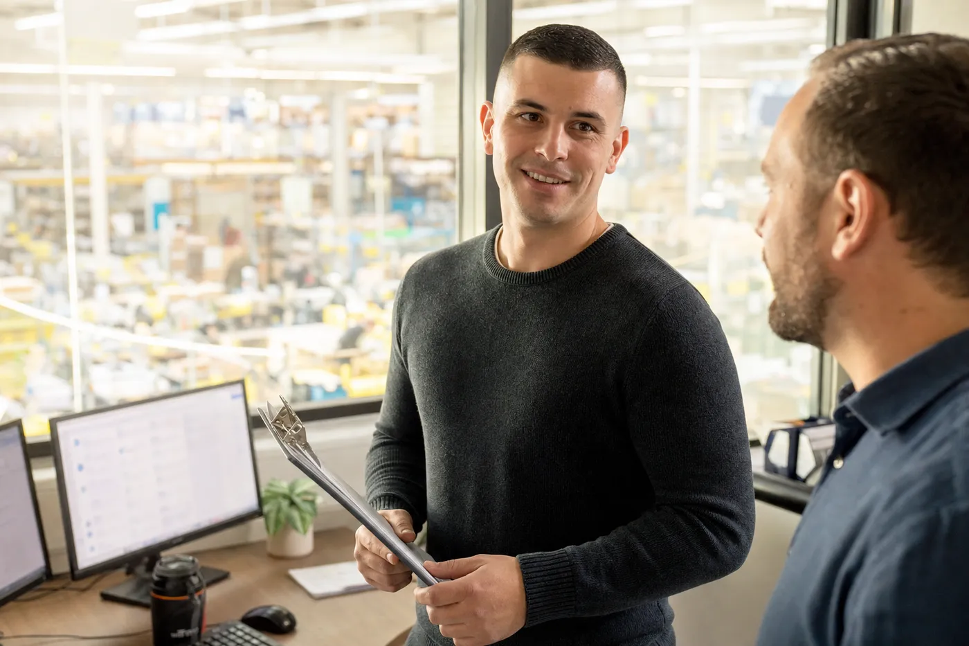 A veteran transitioning to a civilian operations manager role speaks confidently in a sunlit logistics office.